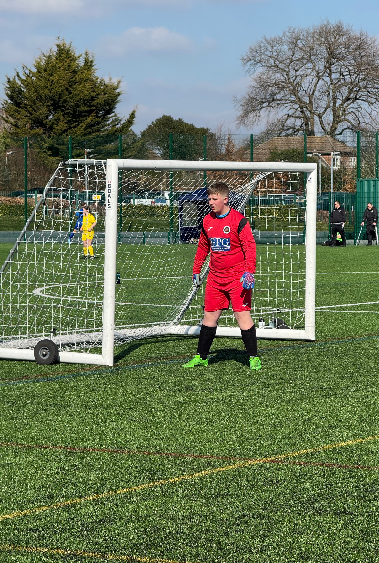 Young goalkeeper on football pitch
